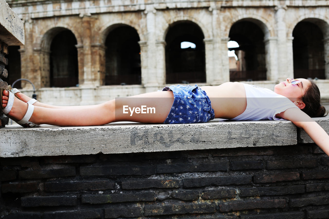 Girl lying on built structure