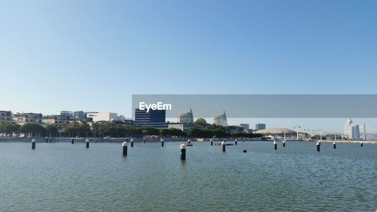 RIVER IN CITY AGAINST CLEAR SKY