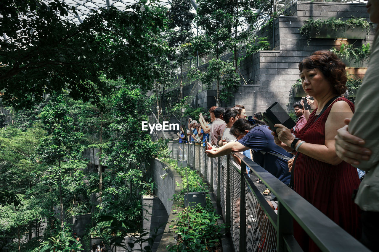 GROUP OF PEOPLE SITTING BY RAILING