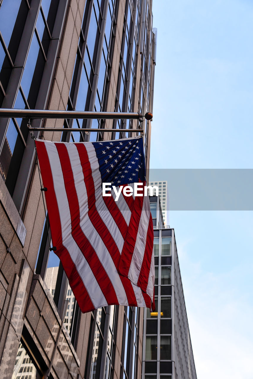 LOW ANGLE VIEW OF FLAG AGAINST BUILDINGS