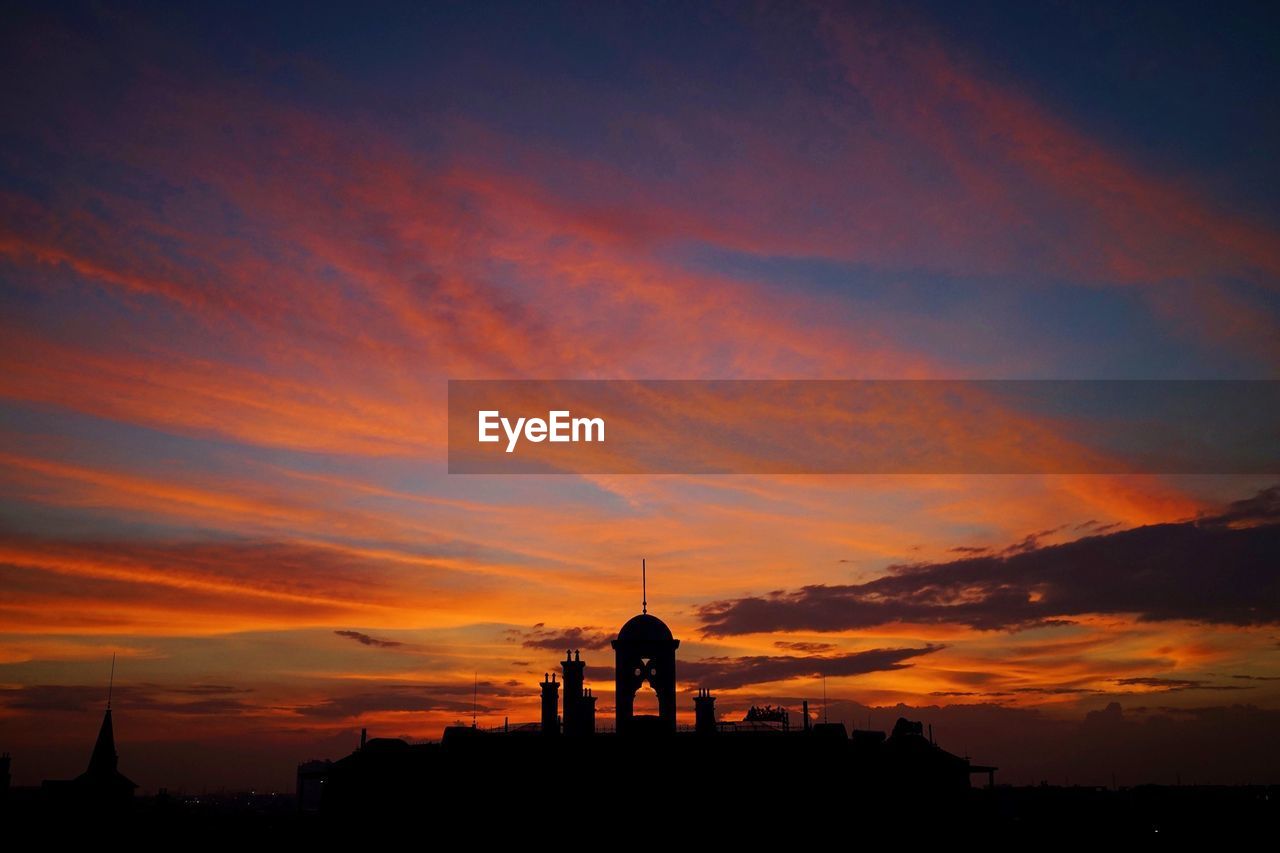 Silhouette built structure against sky during sunset