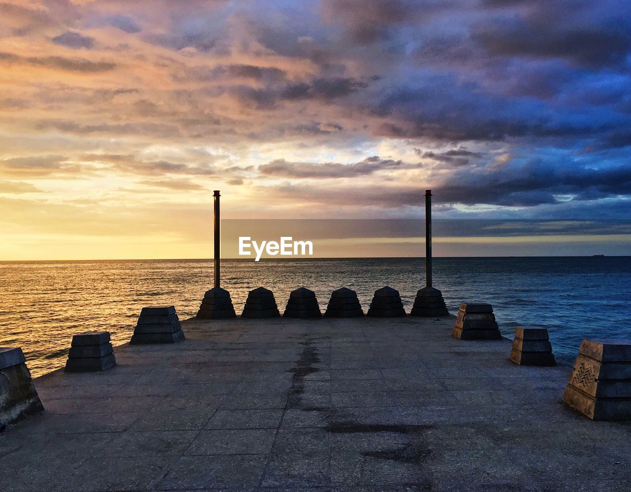 Scenic view of sea by pier against sky during sunset