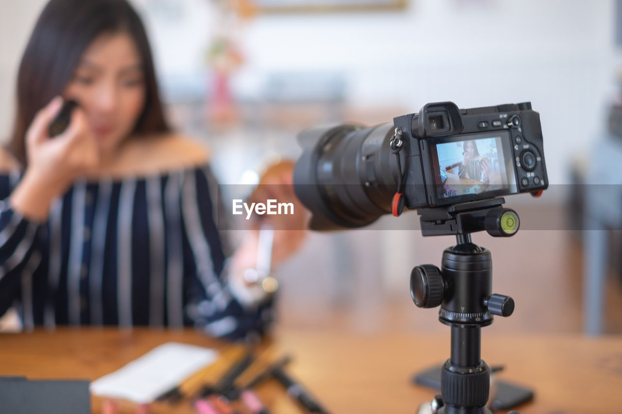 Young woman make-up blogging at home