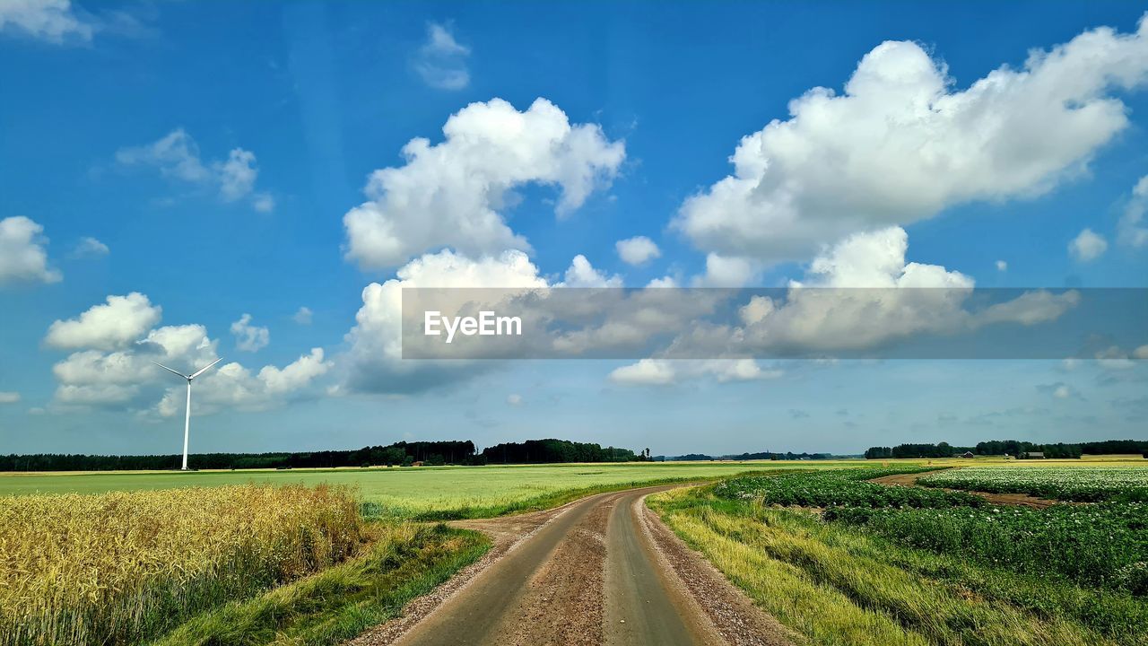 PANORAMIC VIEW OF EMPTY ROAD ON FIELD AGAINST SKY