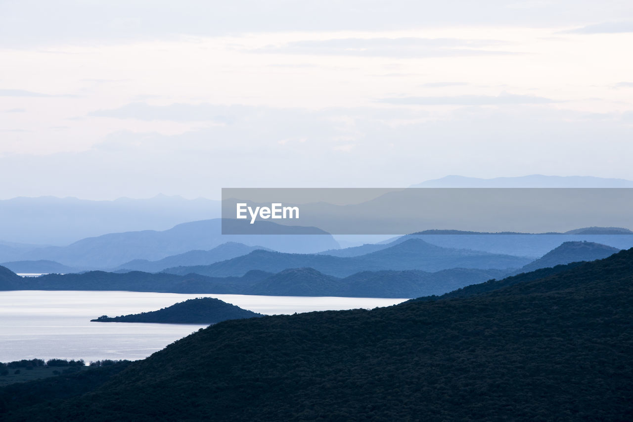 Scenic view of lake and mountains against sky