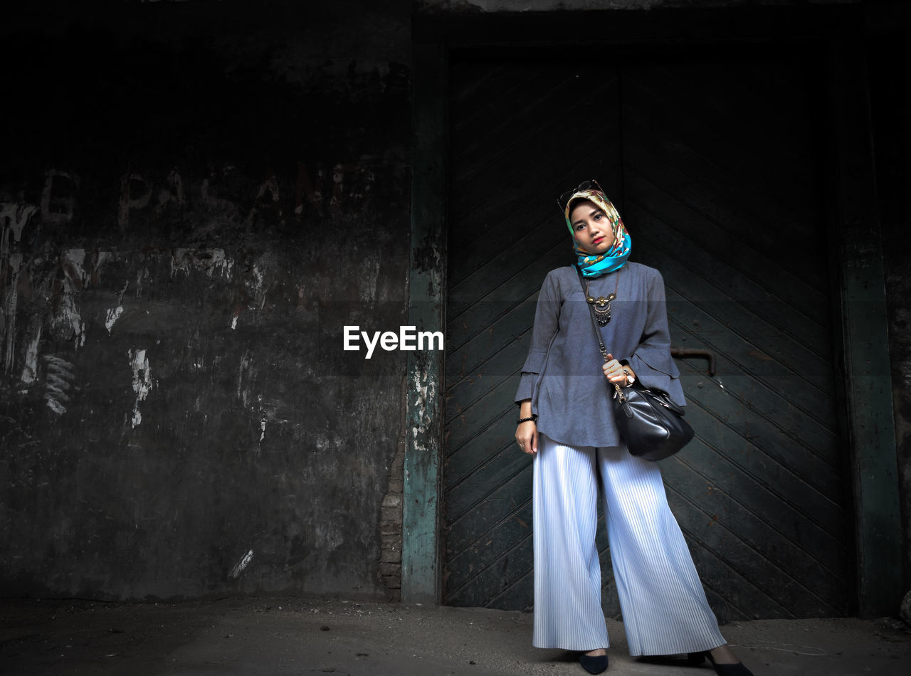 Woman standing against wall