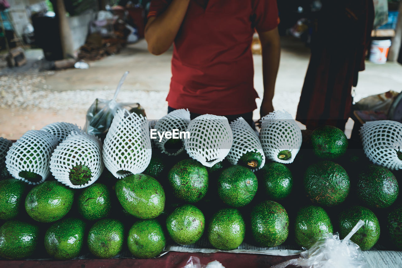 Midsection of vendor selling fruits at market