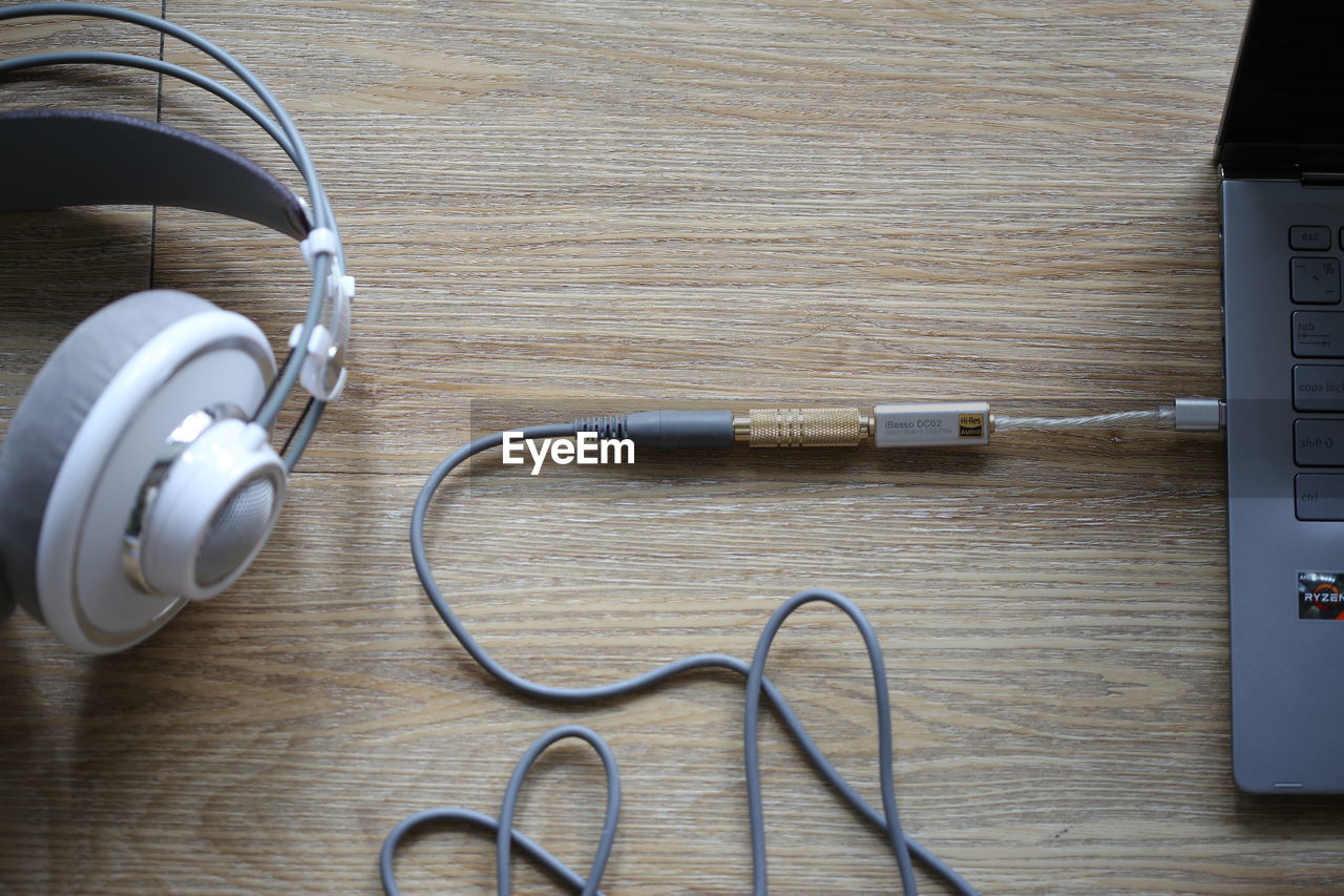 gadget, headphones, technology, cable, indoors, listening, table, audio equipment, communication, electronic device, wood, electricity, no people, music, wireless technology, high angle view, still life, equipment, directly above, computer