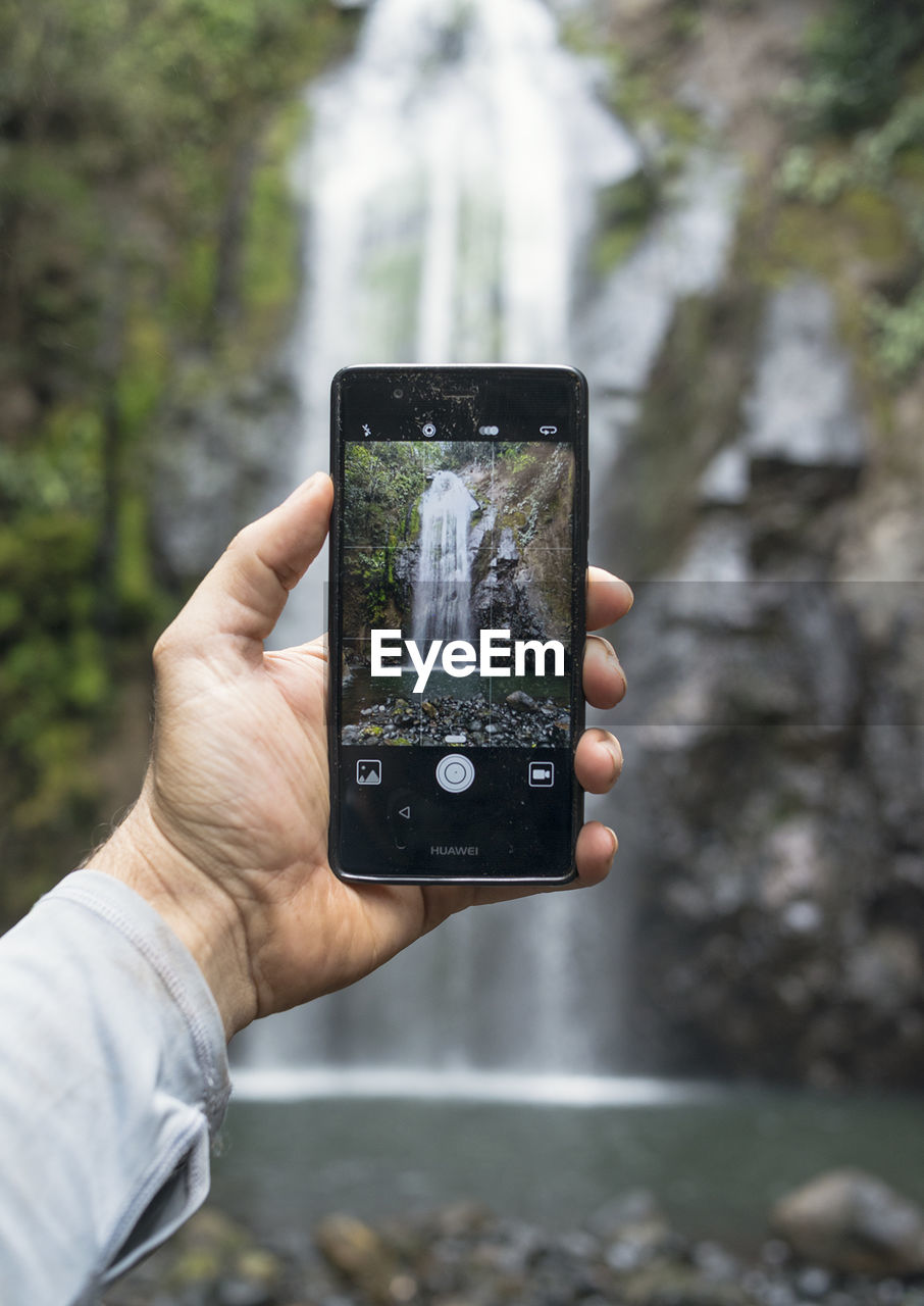 CLOSE-UP OF MAN HOLDING SMART PHONE