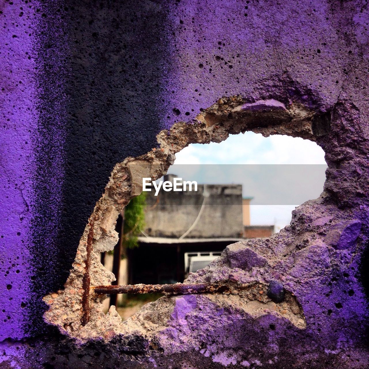 View of a building through broken wall hole