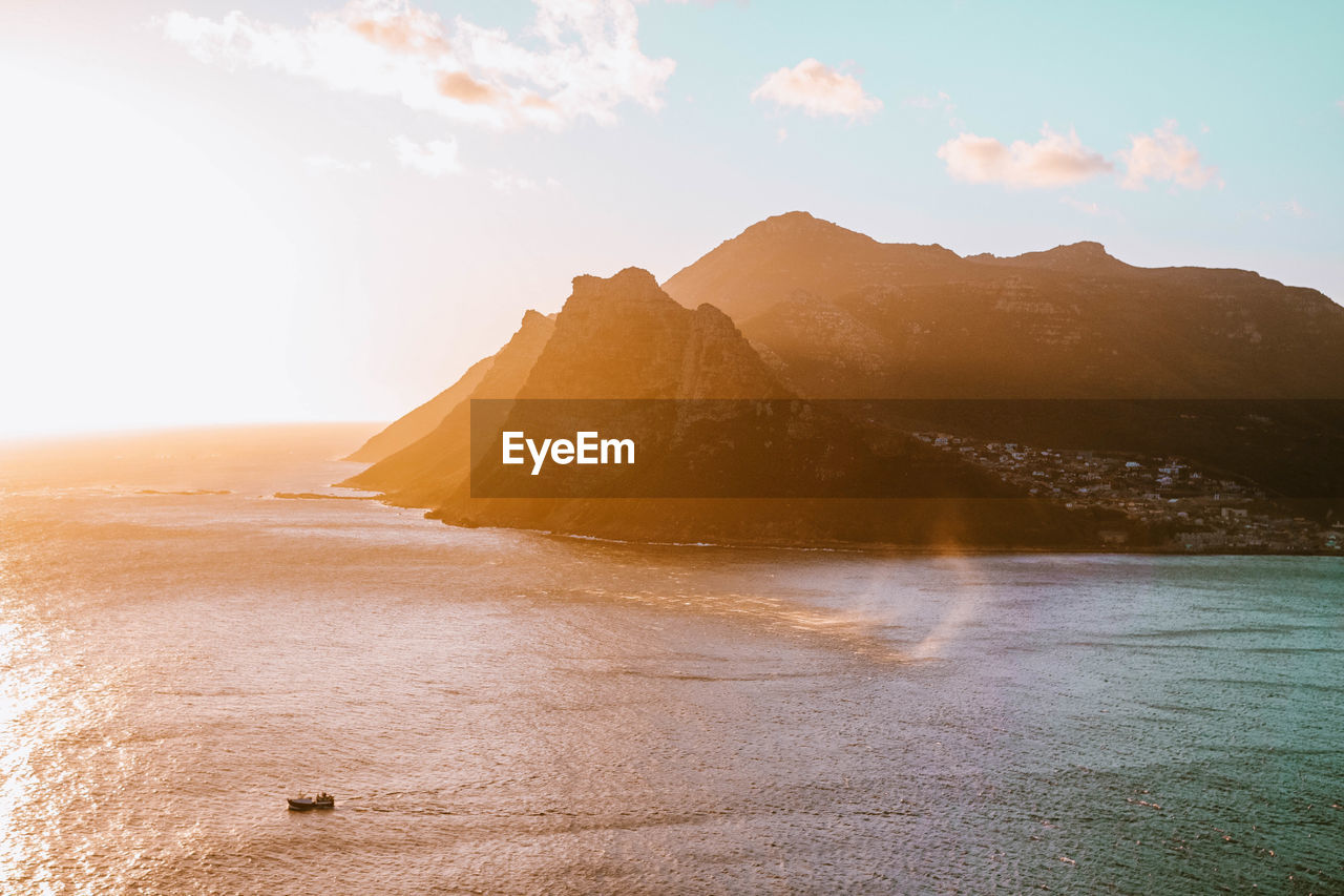 Scenic view of sea and mountains during sunny day