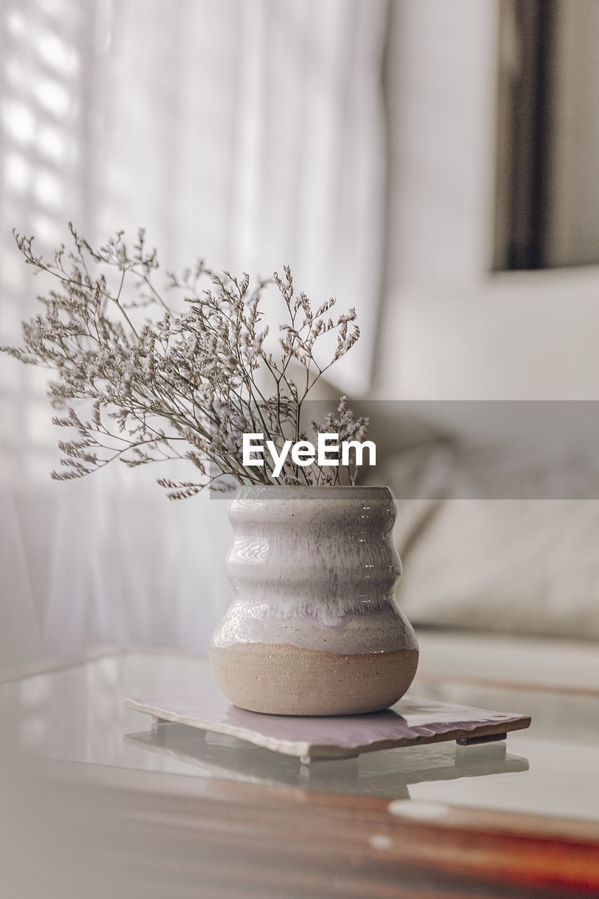 Close-up of flower vase on table at home