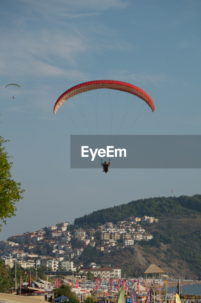 PEOPLE PARAGLIDING OVER MOUNTAIN
