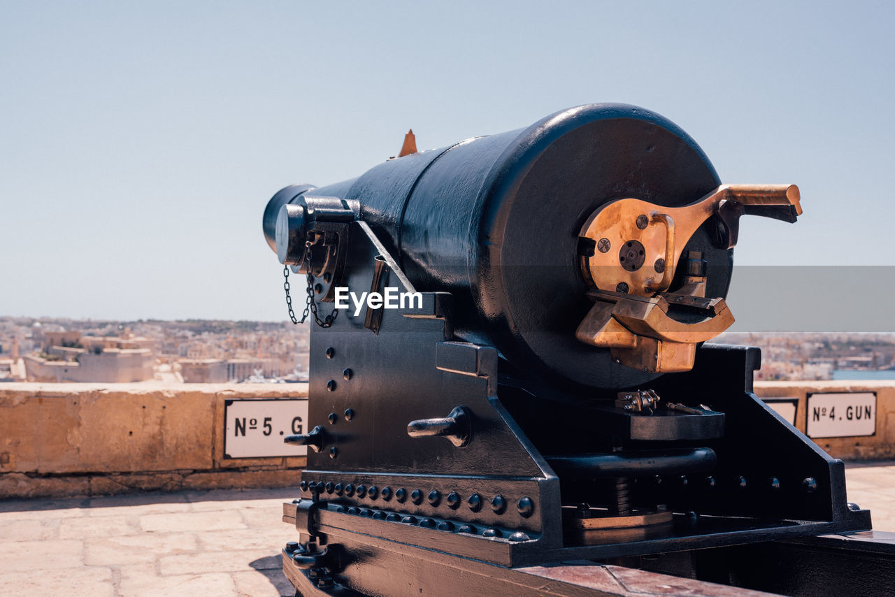 CLOSE-UP OF OLD MACHINE PART AGAINST SKY