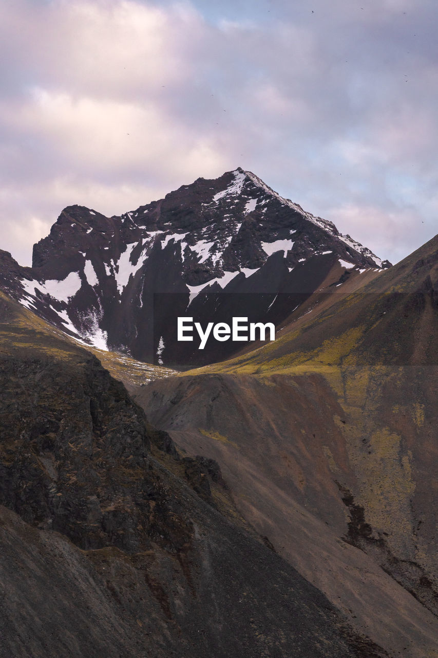 Picturesque view of vestrahorn mountain range with snowy peaks under cloudy sky in winter