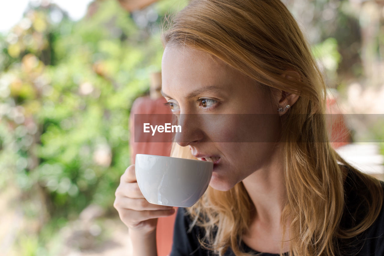 Woman drinking coffee outdoors