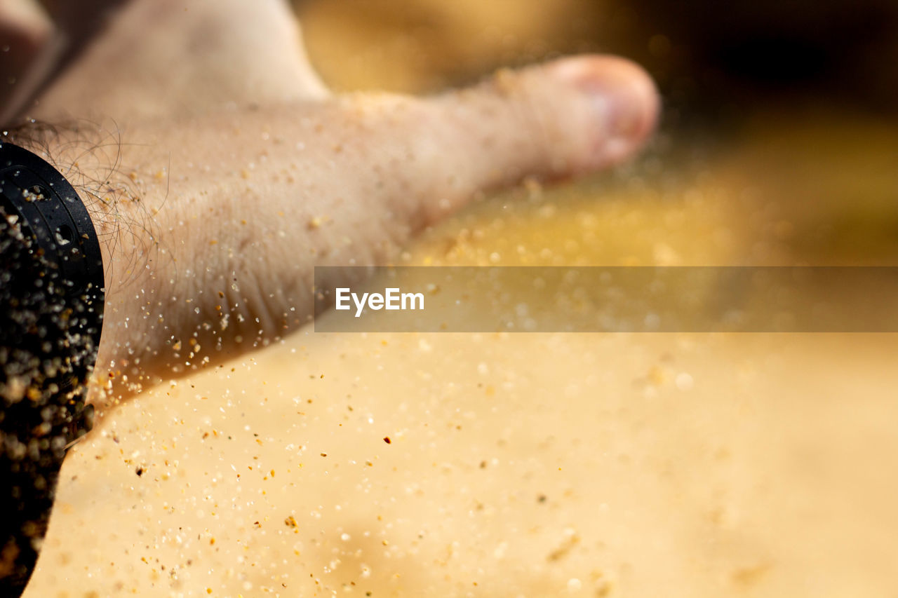 Close-up of person hand with sand