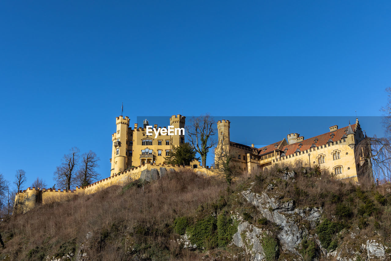 LOW ANGLE VIEW OF OLD BUILDING AGAINST BLUE SKY