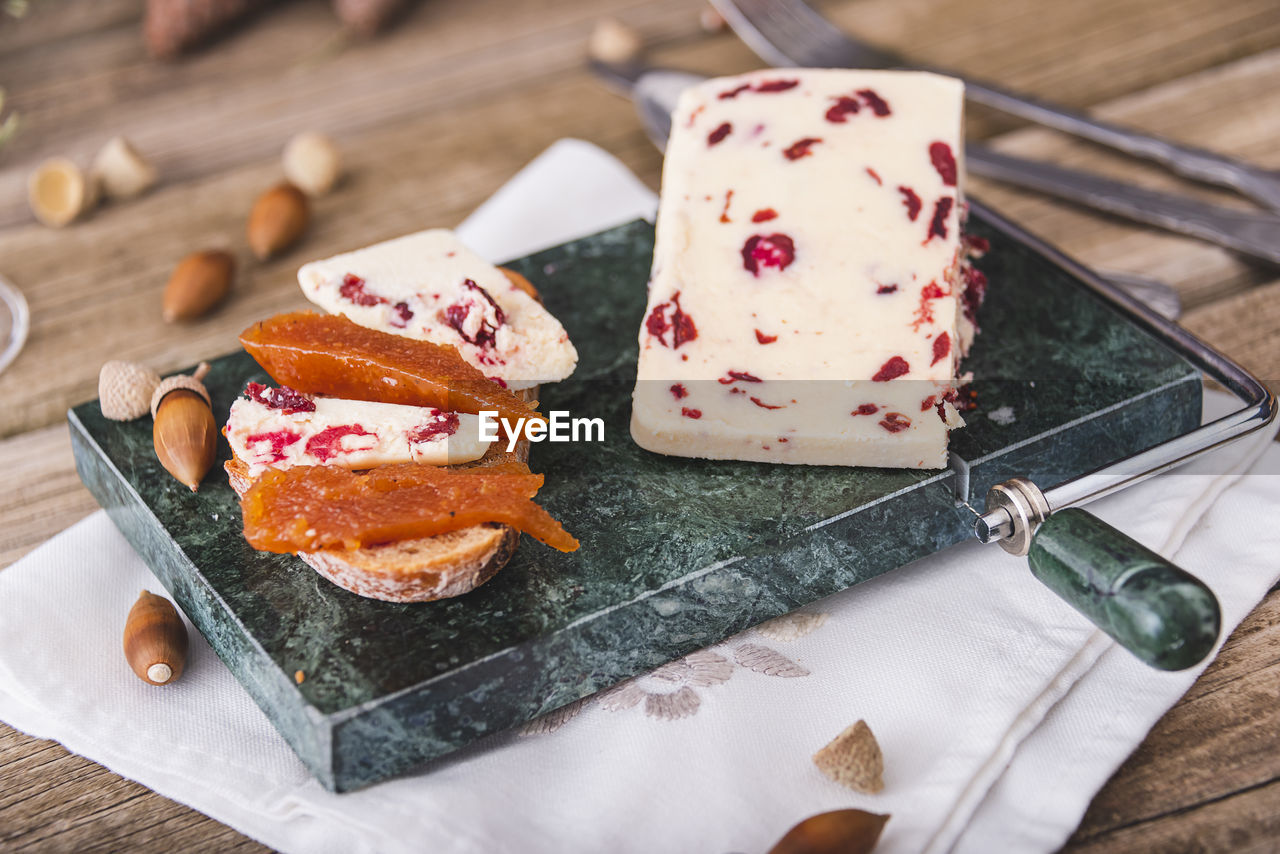 Delicious british cheddar cheese with cranberry on a marble cheese cutting table.