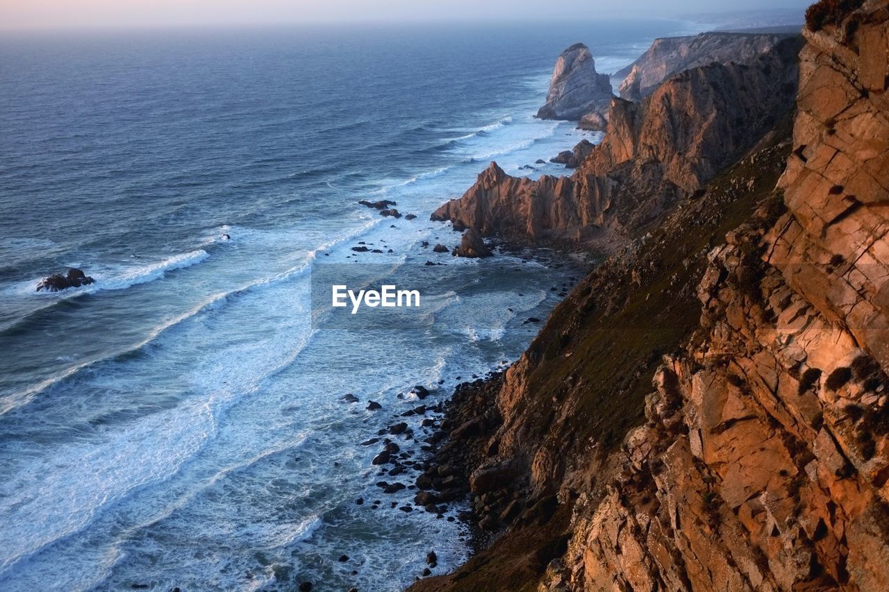 Scenic view of mountains by sea against sky