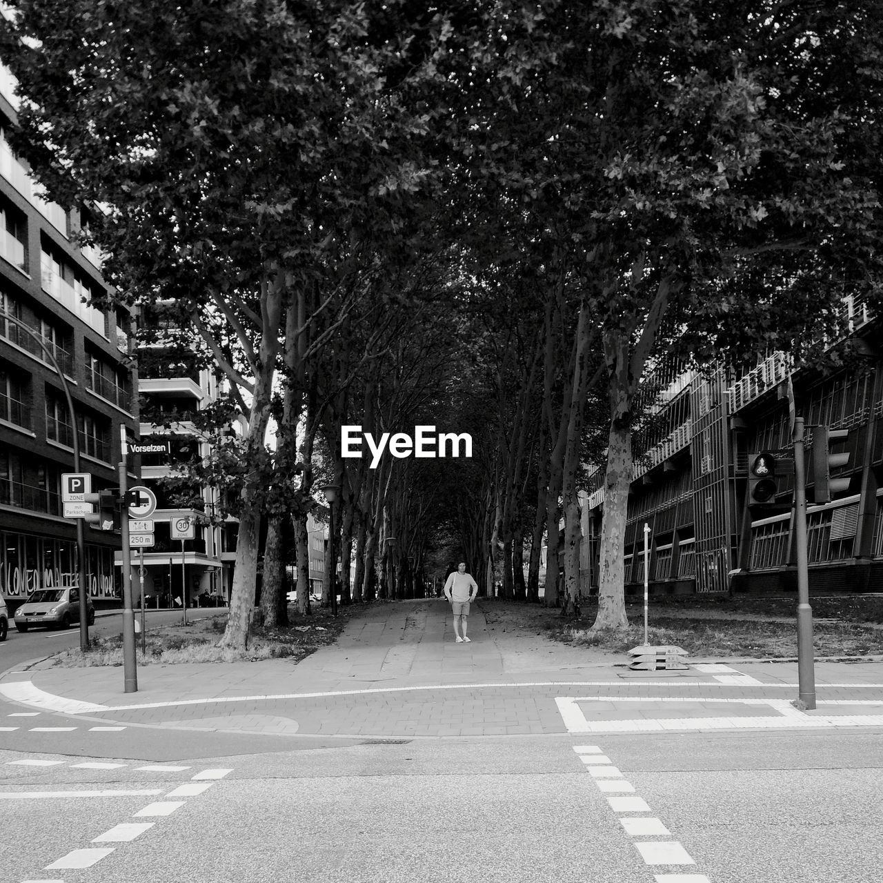 REAR VIEW OF MAN ON ROAD AGAINST TREES