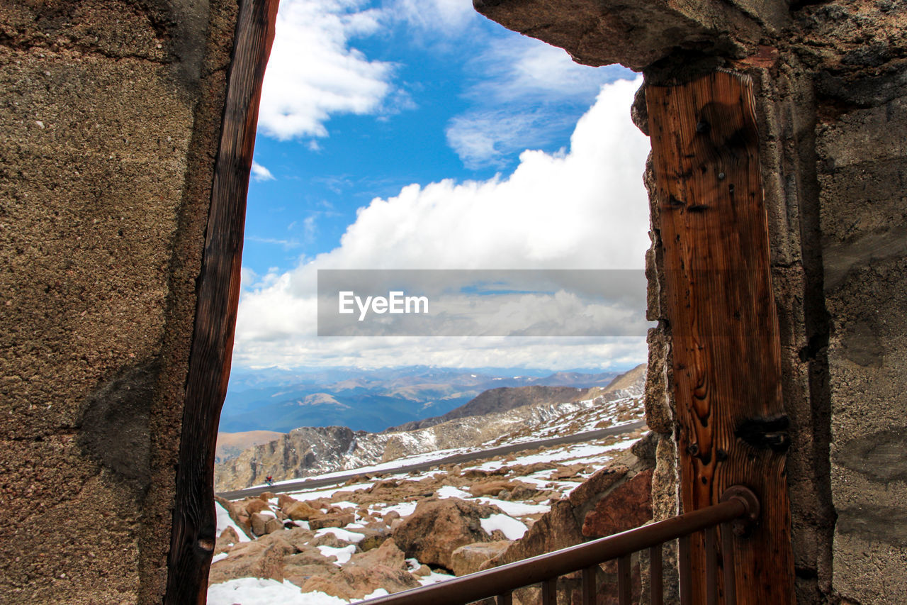 Scenic view of mountains against sky seen through window