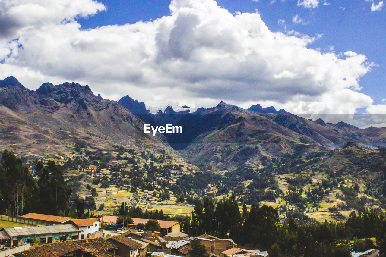 SCENIC VIEW OF MOUNTAINS AND TREES AGAINST SKY