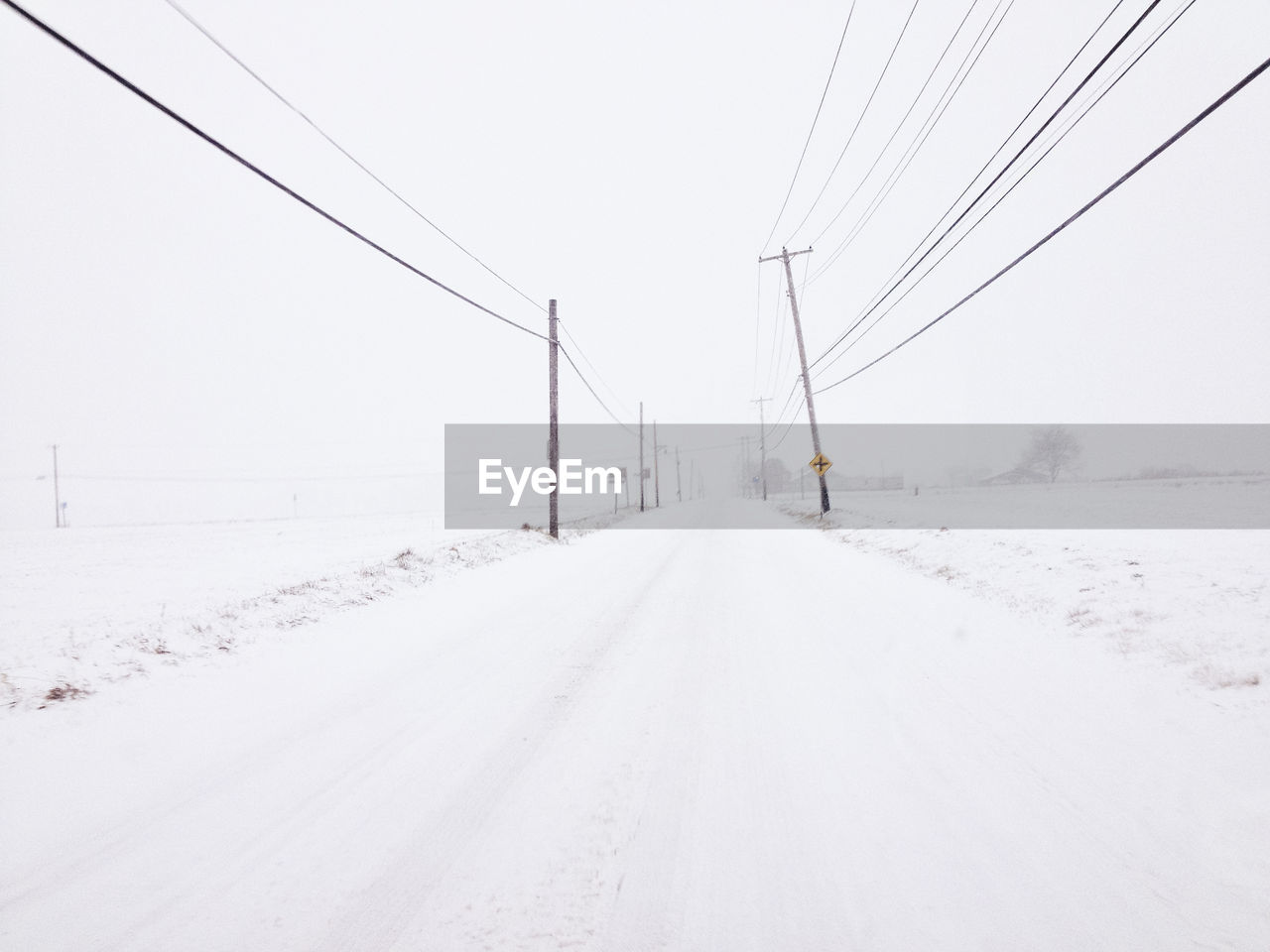 SNOW COVERED ROAD AGAINST SKY