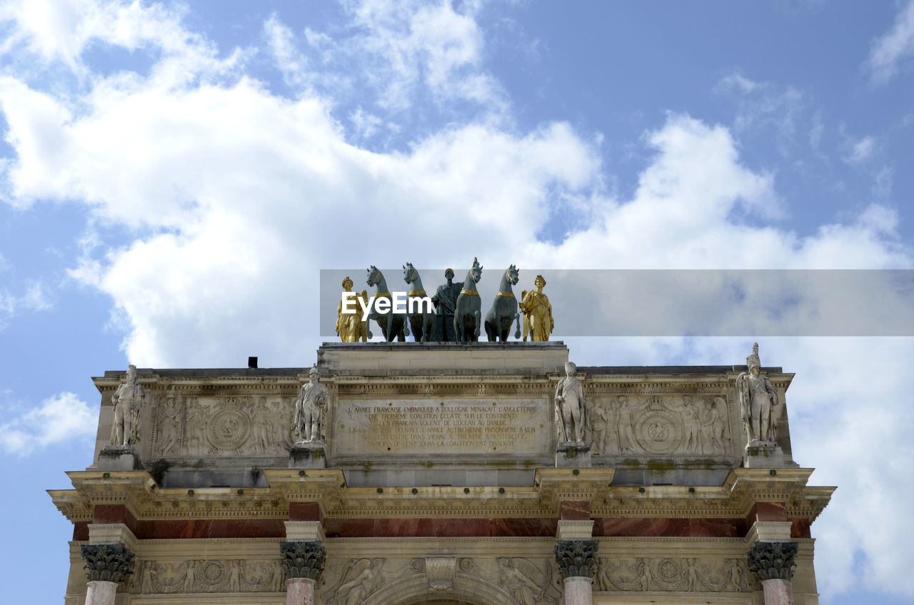 Low angle view of brandenburg gate against cloudy sky