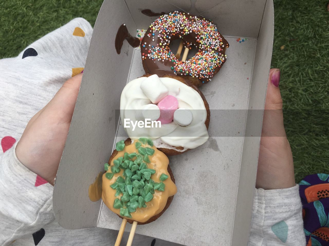 HIGH ANGLE VIEW OF HAND HOLDING CAKE