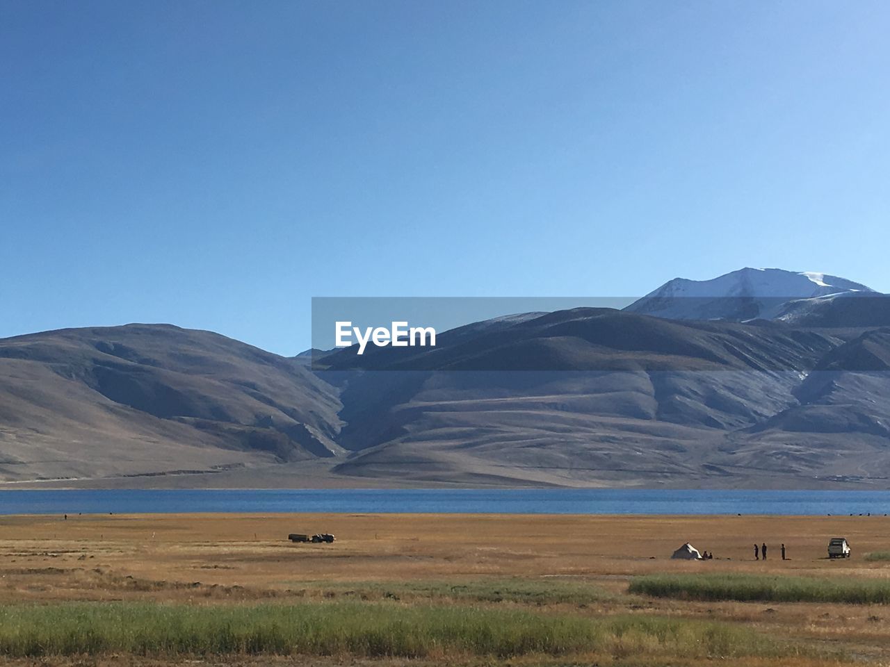 Scenic view of lake and mountains against blue sky