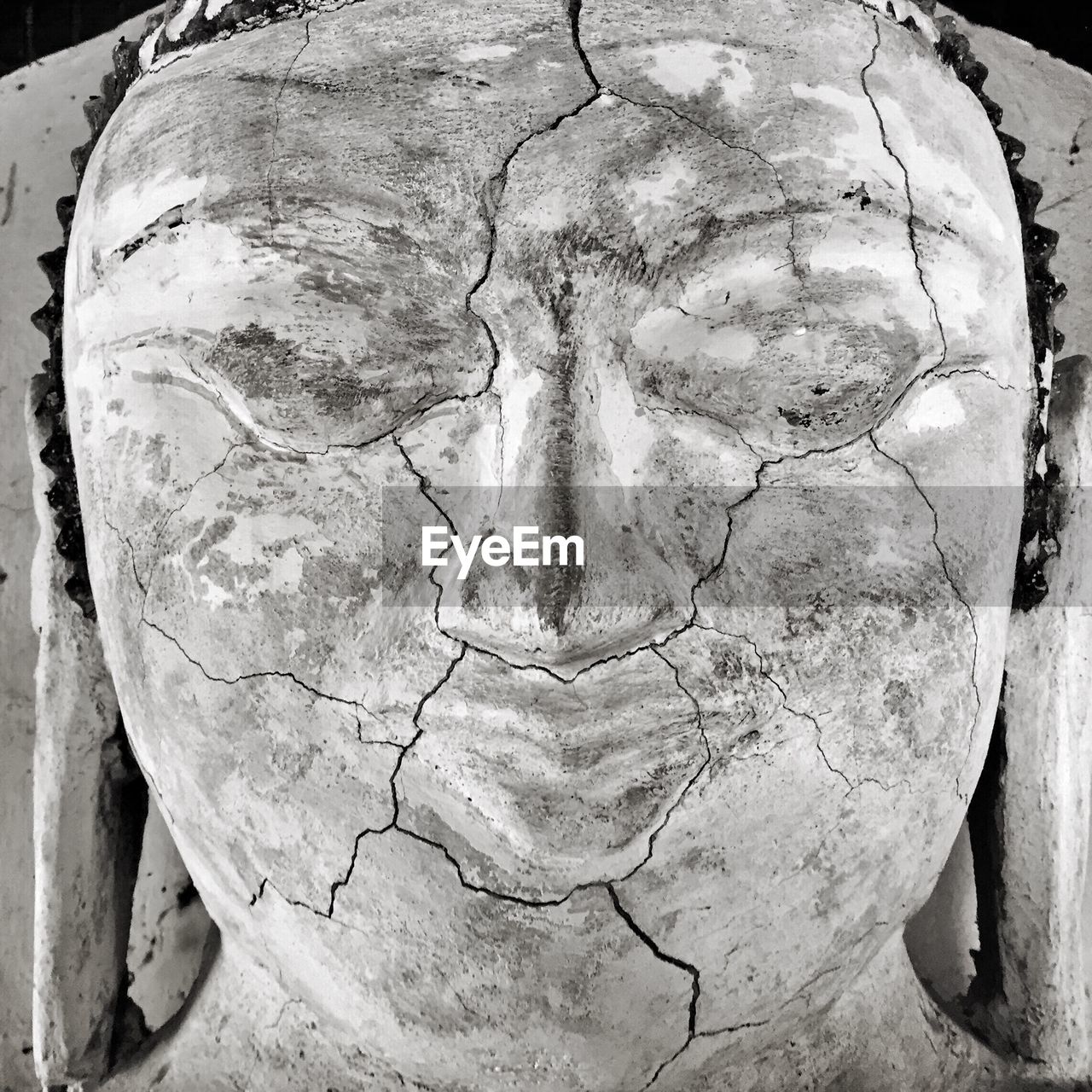 Close-up of cracks on buddha face