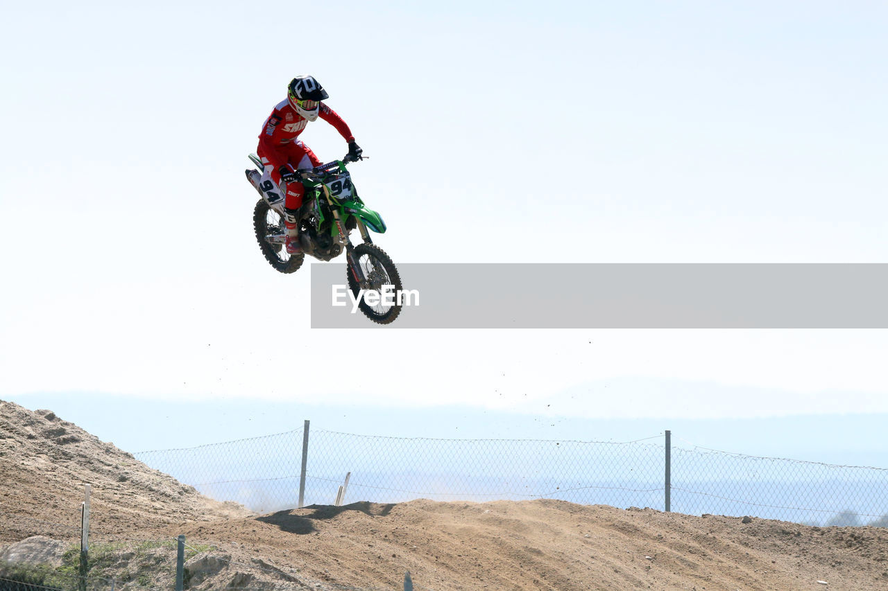 Low angle view of man riding bicycle against sky