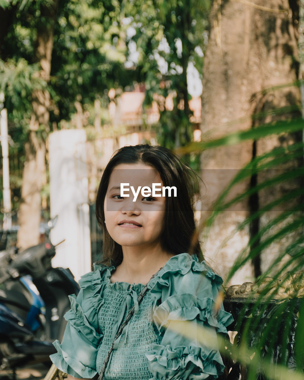 Portrait of smiling woman standing against trees