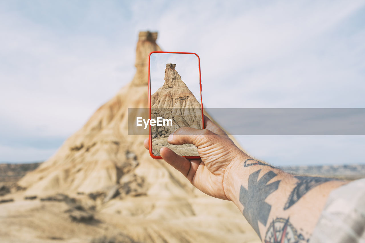 Taking photos with a smartphone of a castil de tierra peak, close-up shot