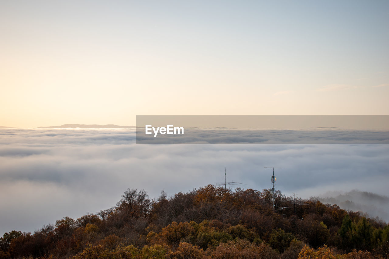 sky, morning, hill, environment, nature, cloud, horizon, tree, landscape, plant, scenics - nature, beauty in nature, dawn, land, fog, tranquility, no people, sunrise, forest, sunlight, tranquil scene, social issues, outdoors, travel, non-urban scene, copy space, rural area, environmental conservation, travel destinations, sun, idyllic, architecture, tourism, water, mist, rural scene, twilight, technology, autumn, blue, orange color