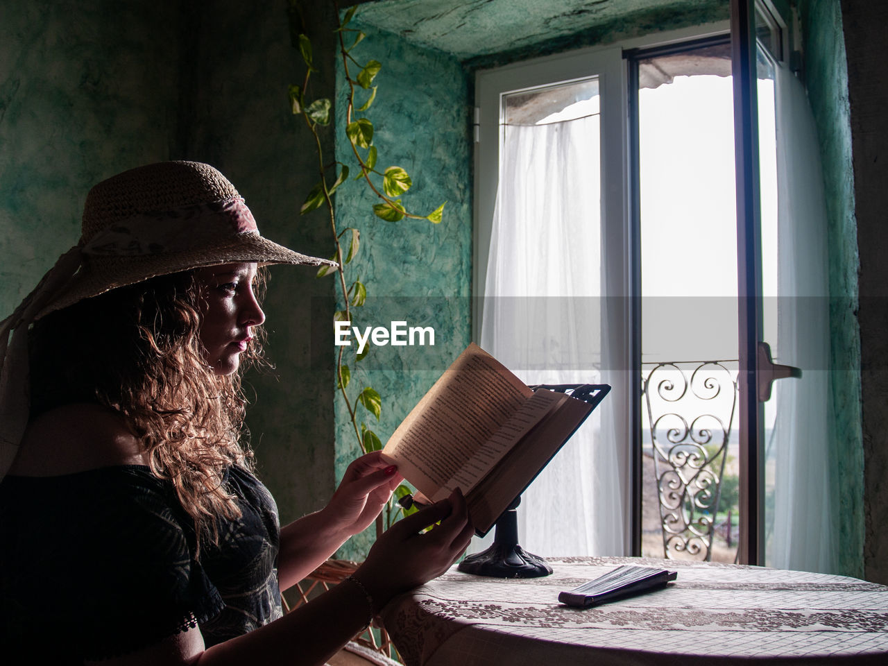 Woman reading book while sitting at home