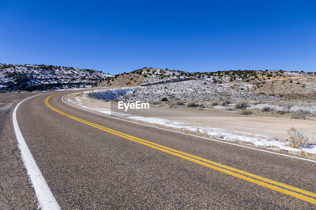 Empty road curving along arid winter landscape in springdale, utah