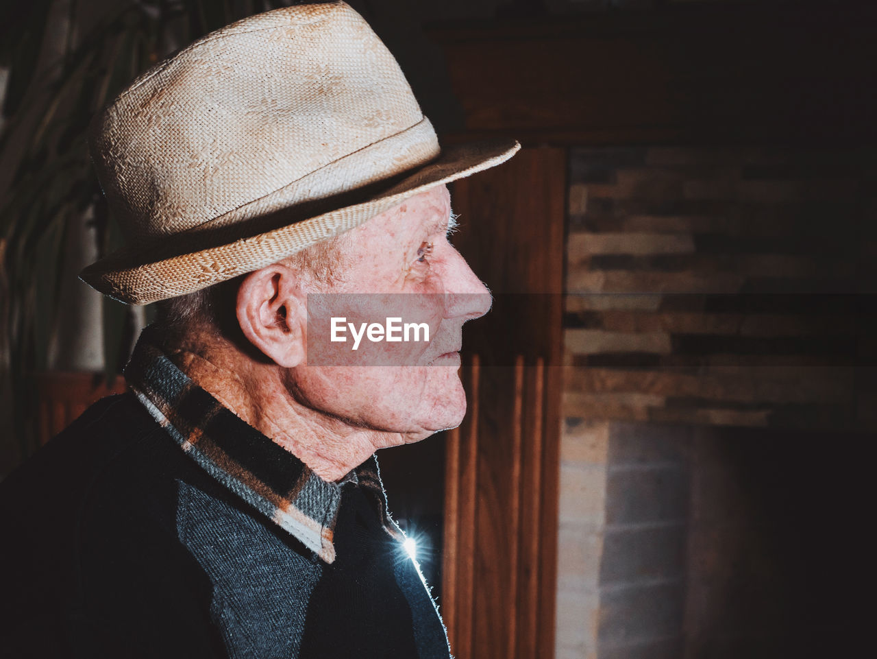 Close-up of senior man wearing hat at home