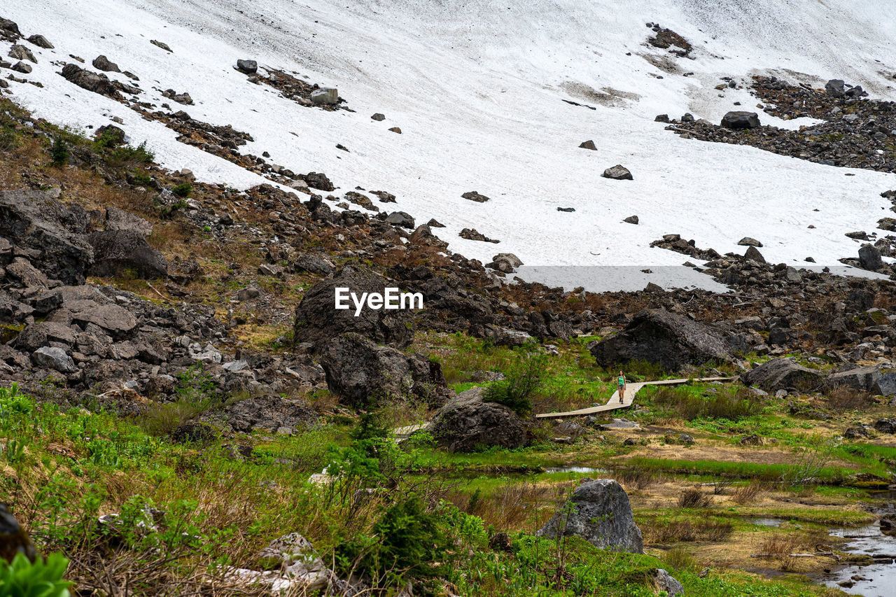 Female hiker walking at the edge of the snowfield in washington