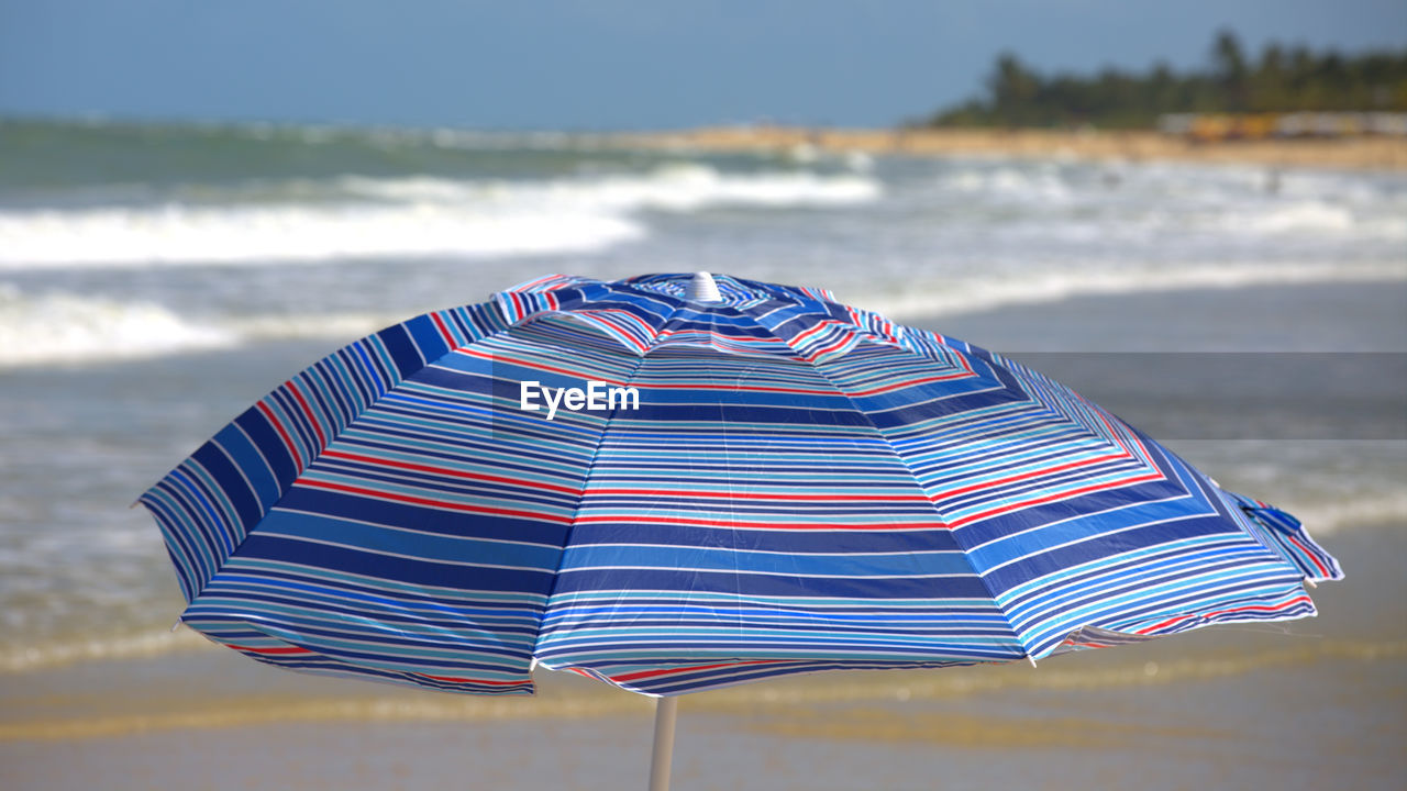 Close-up of umbrella on beach