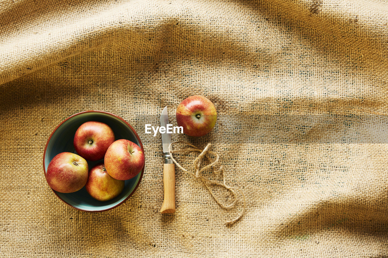 HIGH ANGLE VIEW OF APPLES IN CONTAINER ON TABLE