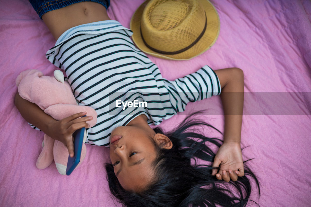 HIGH ANGLE VIEW OF WOMEN LYING ON BED