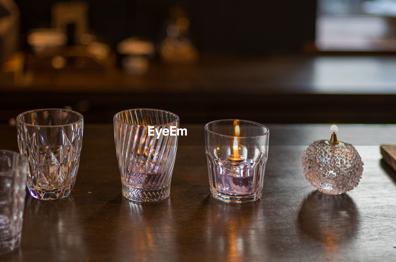 glass, table, food and drink, drinking glass, indoors, household equipment, drink, lighting, no people, refreshment, still life, bar, wood, alcohol, focus on foreground, shot glass, bar counter, close-up, food