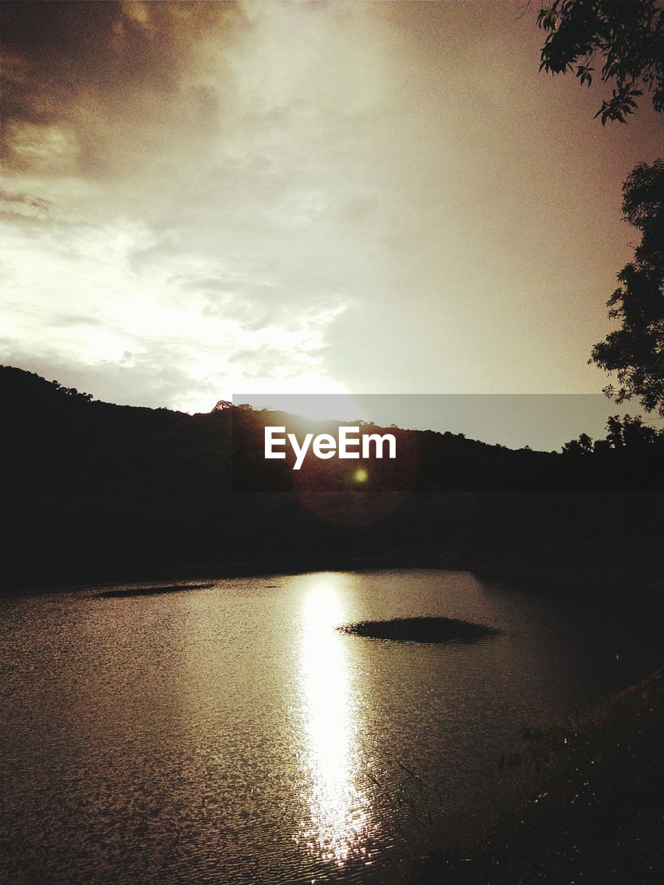 SCENIC VIEW OF LAKE BY SILHOUETTE MOUNTAINS AGAINST SKY