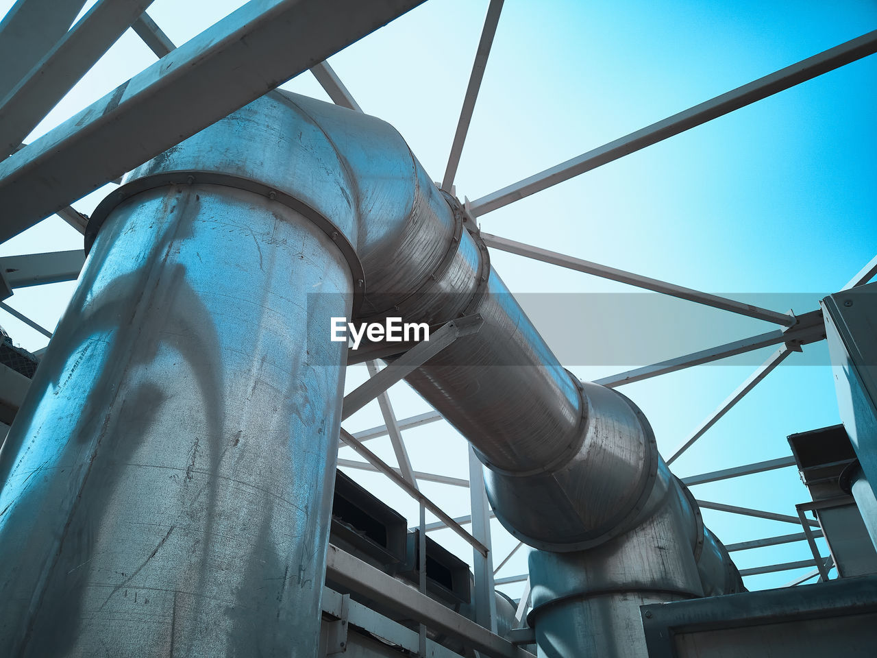 Industrial pipeline against bright blue sky.