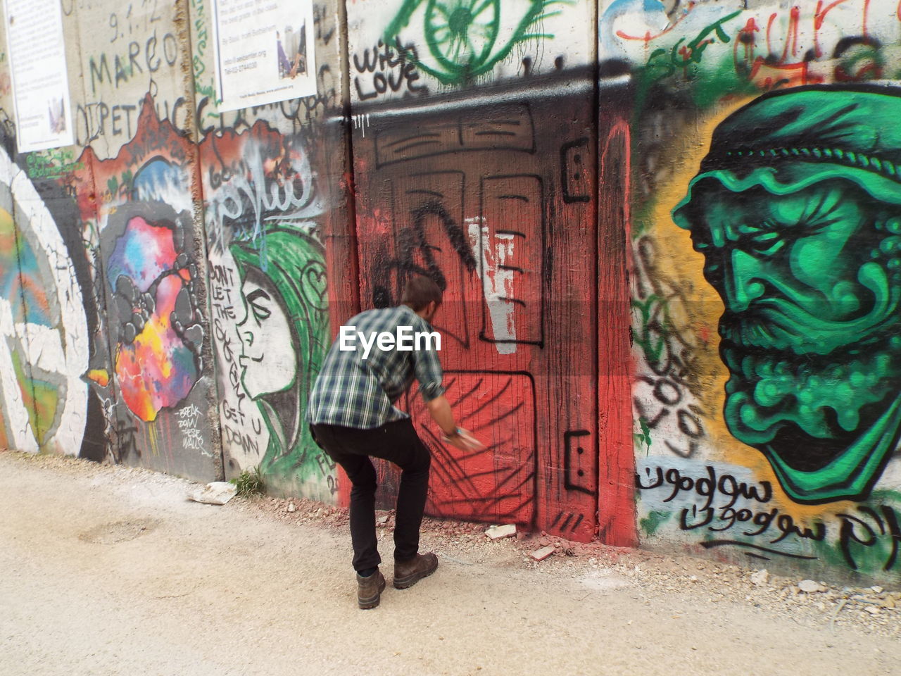 FULL LENGTH OF WOMAN WITH GRAFFITI ON WALL