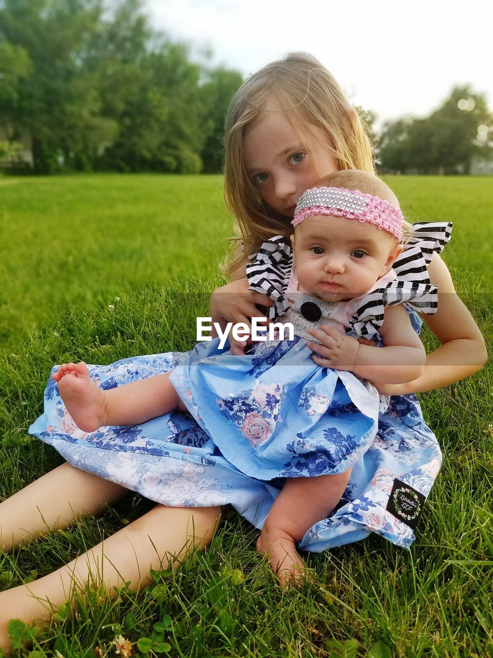 Portrait of sisters sitting on field