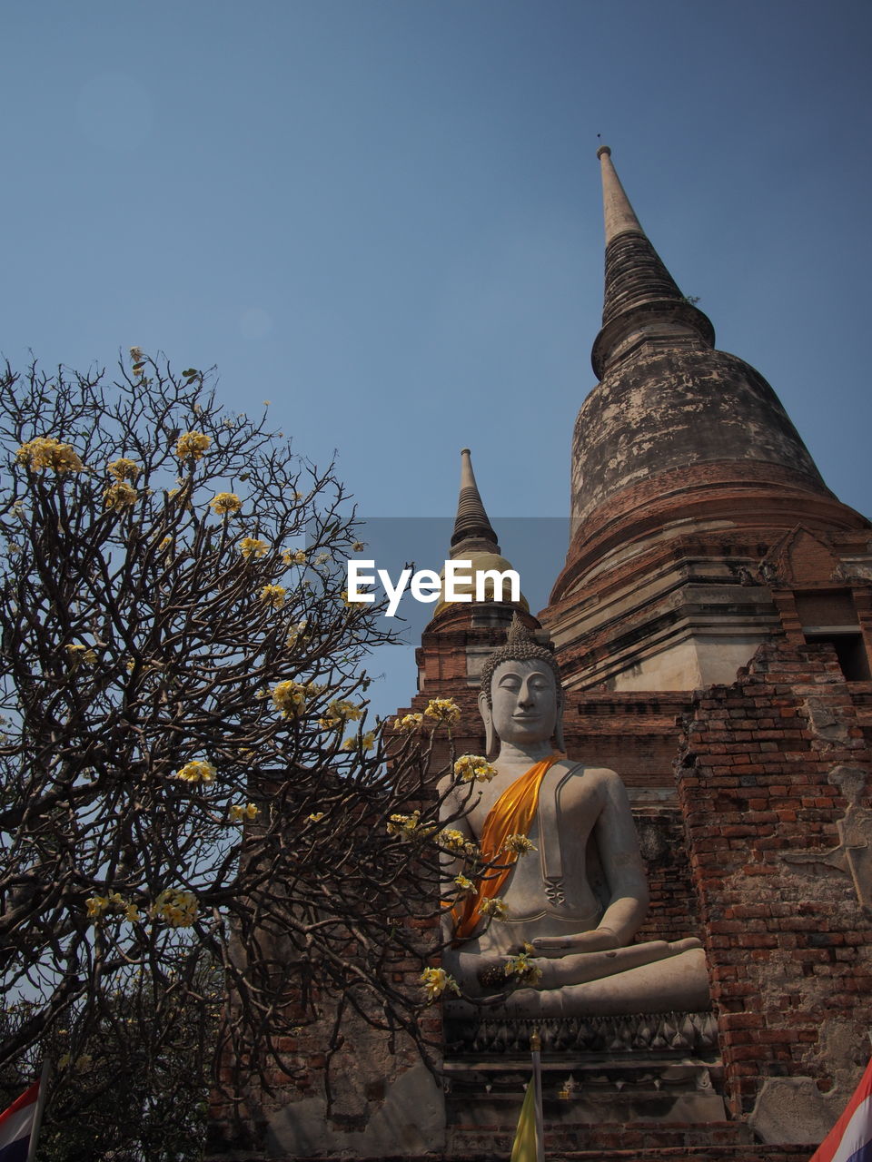 Low angle view of buddha statue against sky