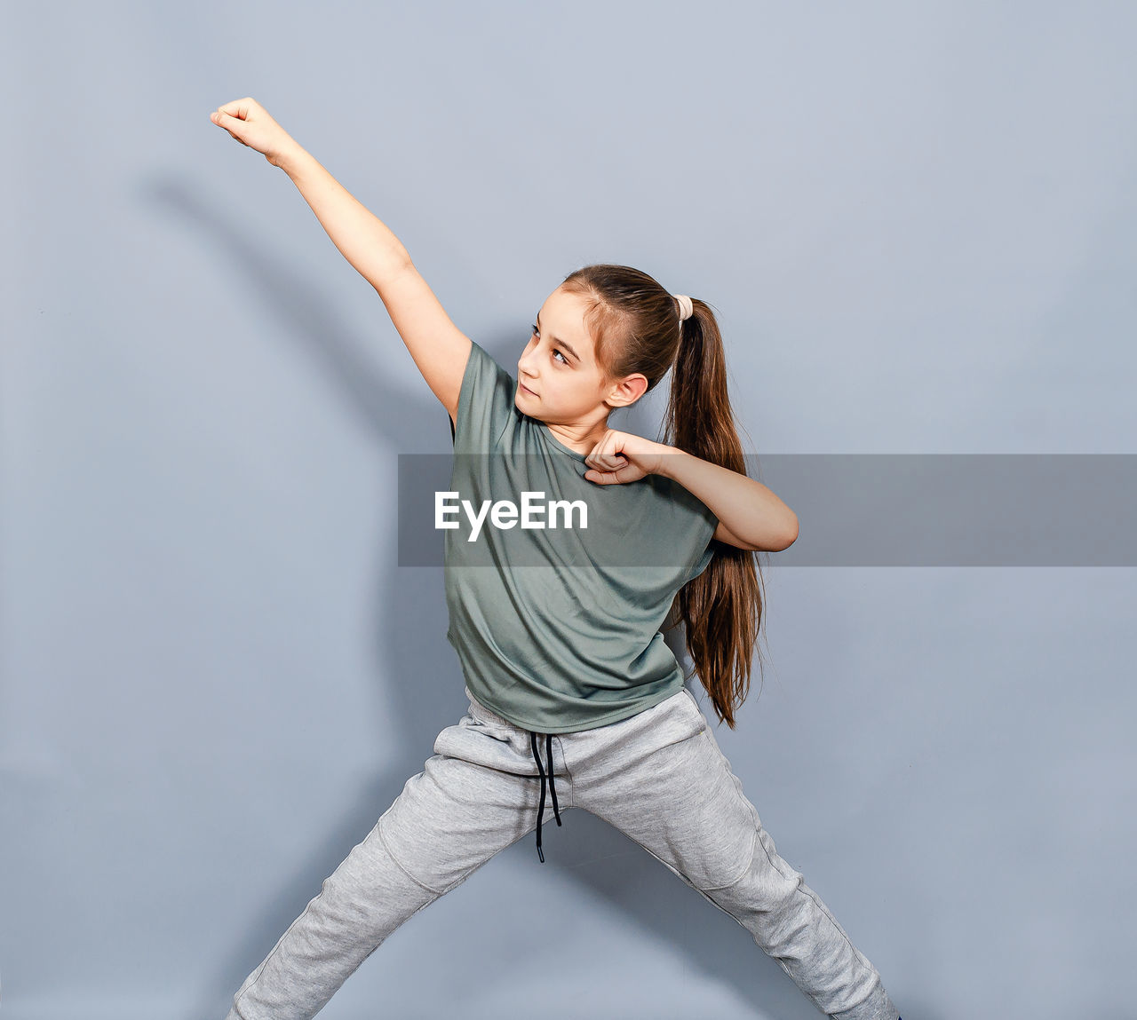 Portrait of young woman exercising against white background